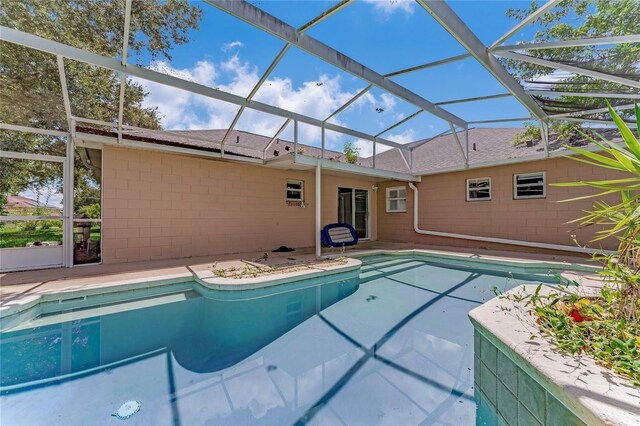 view of swimming pool featuring a patio and a lanai