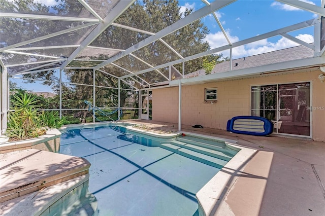 view of swimming pool with glass enclosure and a patio area