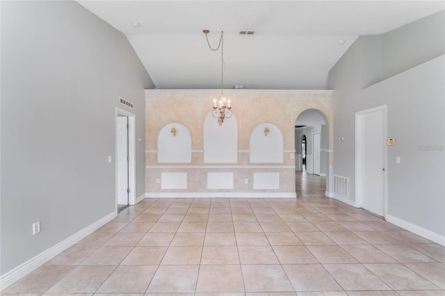 tiled spare room featuring high vaulted ceiling and an inviting chandelier