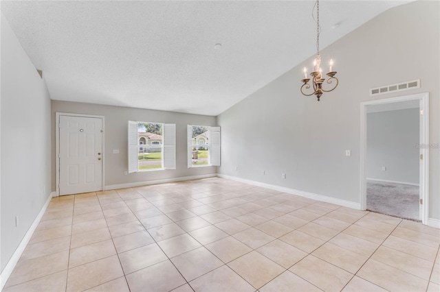 spare room featuring high vaulted ceiling, a chandelier, light tile patterned floors, and a textured ceiling