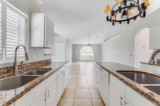 kitchen with dishwasher, sink, a textured ceiling, and white cabinetry