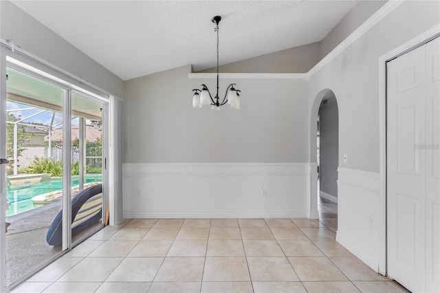 unfurnished dining area featuring light tile patterned floors, an inviting chandelier, vaulted ceiling, and a textured ceiling