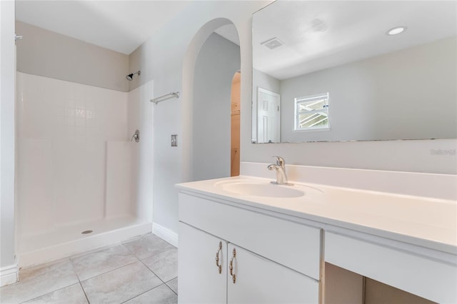 bathroom featuring vanity, tile patterned flooring, and walk in shower