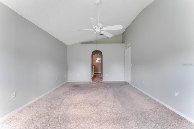 empty room featuring light carpet, vaulted ceiling, and ceiling fan