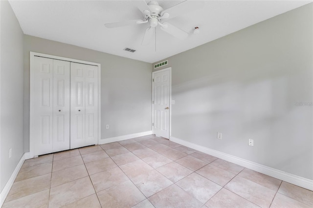 unfurnished bedroom featuring ceiling fan, a closet, and light tile patterned floors