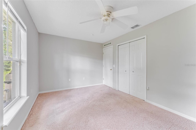 unfurnished bedroom featuring ceiling fan, carpet floors, and a closet