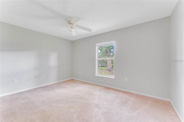 carpeted empty room with ceiling fan and a textured ceiling