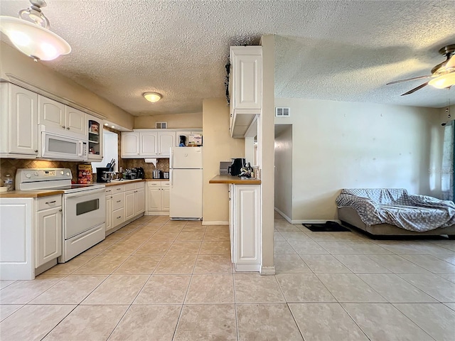 kitchen featuring white cabinetry, white appliances, and a textured ceiling