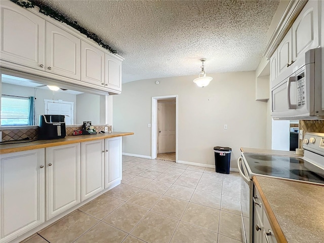 kitchen with light tile patterned floors, white cabinets, decorative light fixtures, and electric range oven