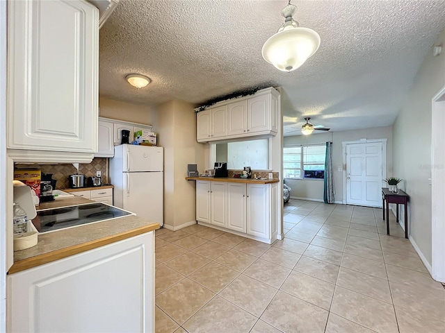 kitchen with backsplash, ceiling fan, white cabinets, white fridge, and light tile patterned flooring