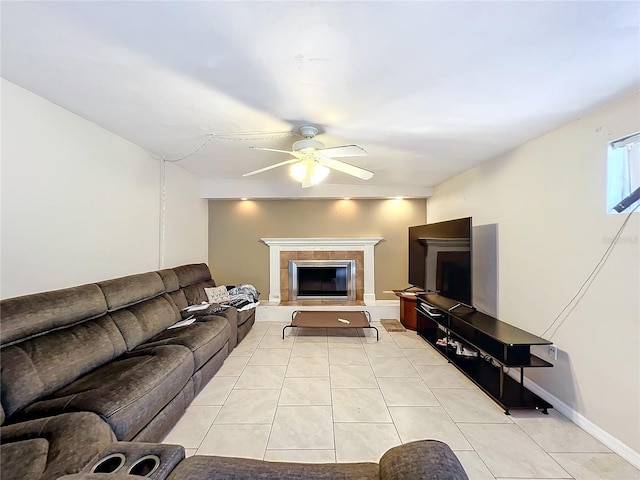 tiled living room with ceiling fan and a tiled fireplace