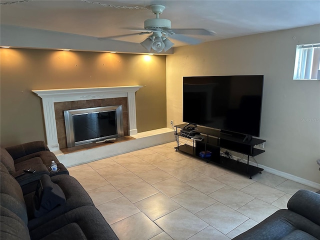 tiled living room featuring a fireplace and ceiling fan