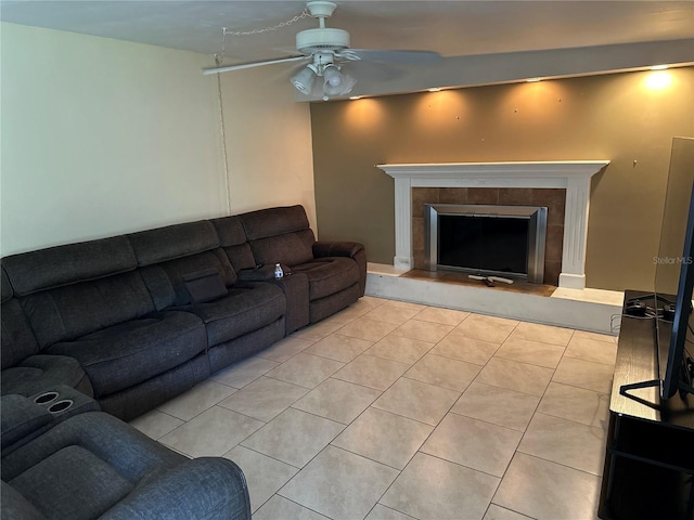 tiled living room featuring ceiling fan and a tiled fireplace