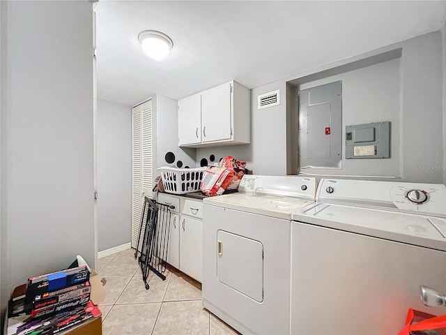 clothes washing area with cabinets, light tile patterned floors, electric panel, and washer and clothes dryer