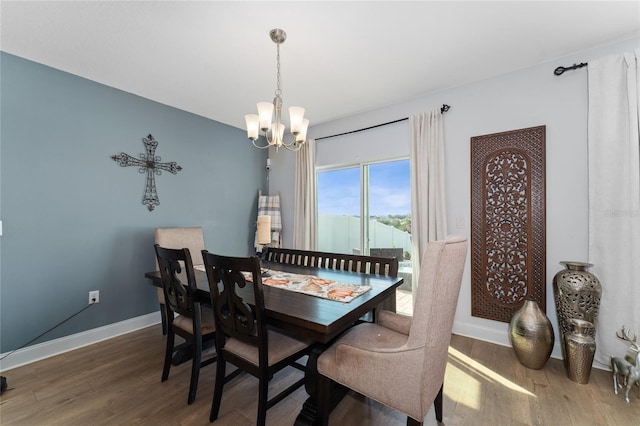 dining area with a notable chandelier and hardwood / wood-style flooring