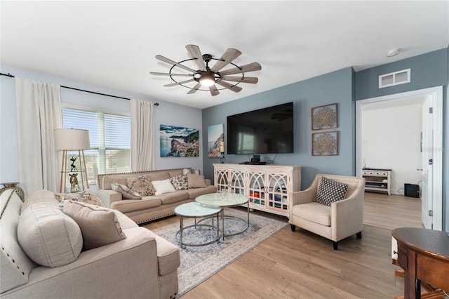 living room featuring light wood-type flooring and ceiling fan