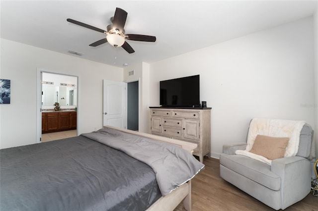 bedroom featuring light hardwood / wood-style floors, connected bathroom, and ceiling fan