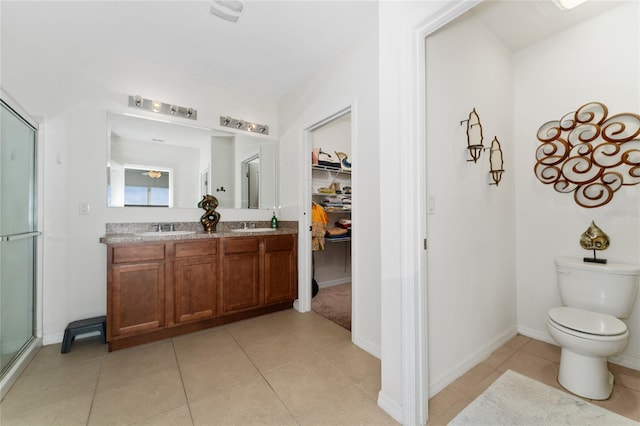 bathroom featuring vanity, toilet, an enclosed shower, and tile patterned floors