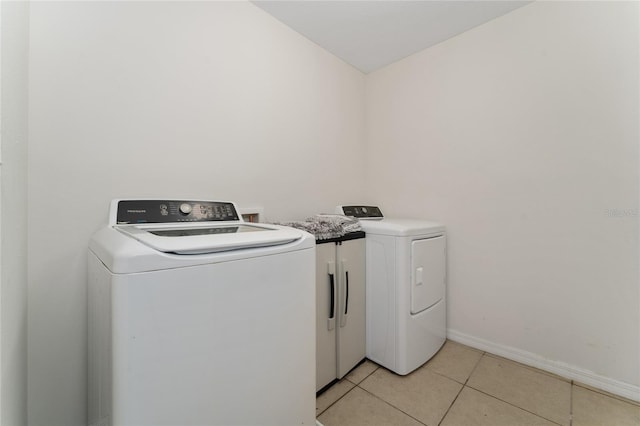 clothes washing area with light tile patterned floors and independent washer and dryer