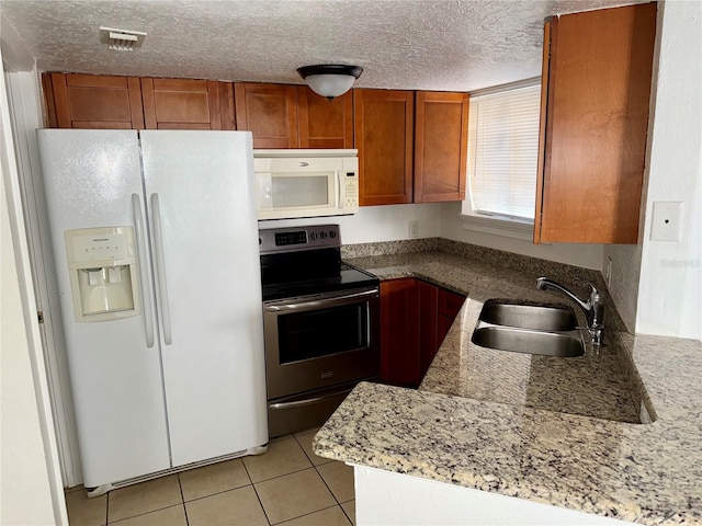 kitchen with white appliances, light stone countertops, sink, light tile patterned flooring, and a textured ceiling