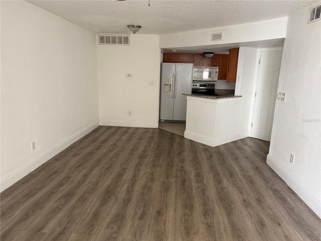 kitchen featuring a textured ceiling, white appliances, and dark hardwood / wood-style flooring