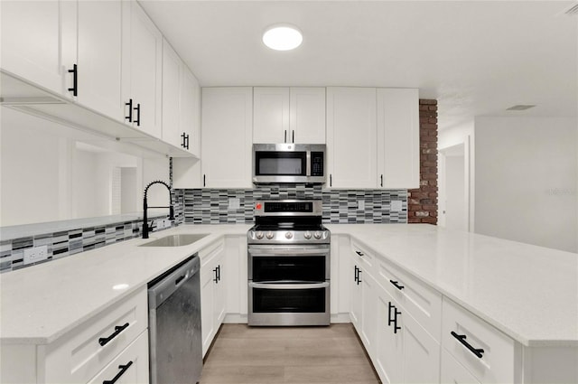 1004 Jersey St, Cocoa, FL 32927 - kitchen with stainless steel appliances, a sink, a peninsula, light countertops, and backsplash
