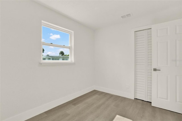 unfurnished bedroom with a closet and light wood-type flooring