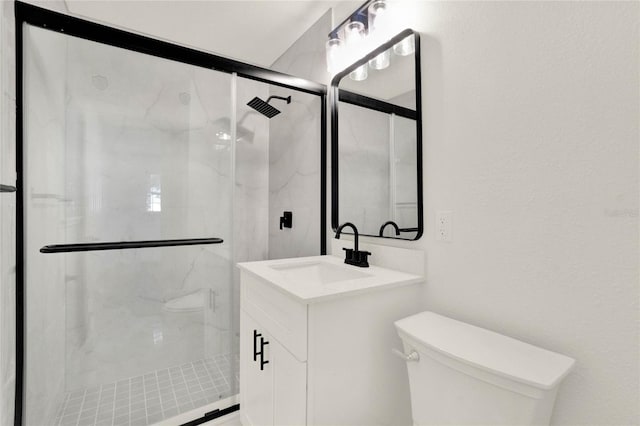 bathroom with walk in shower, vanity, and toilet