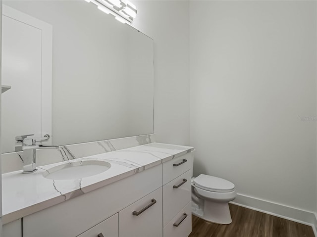 bathroom featuring vanity, toilet, and hardwood / wood-style flooring