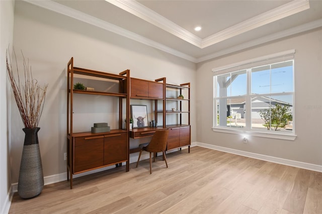 home office featuring crown molding, light wood-type flooring, and a raised ceiling