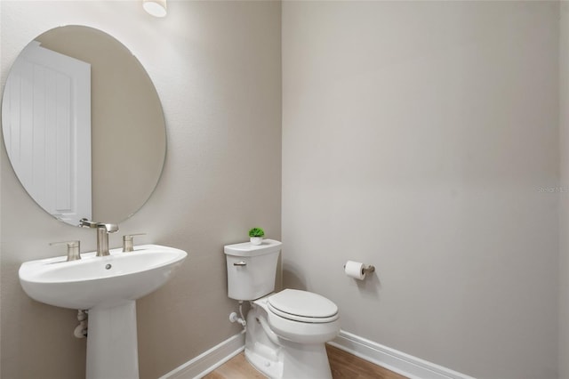 bathroom featuring hardwood / wood-style flooring and toilet