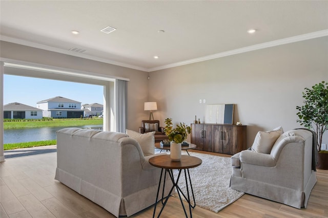 living room featuring light hardwood / wood-style flooring, ornamental molding, and a water view