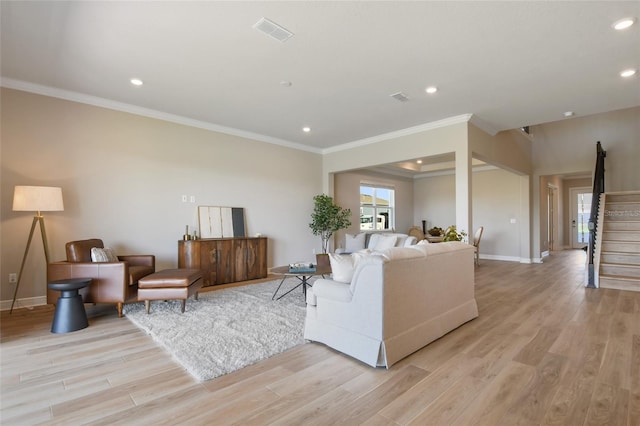 living room with crown molding and light hardwood / wood-style flooring