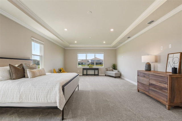 bedroom with ornamental molding, a tray ceiling, and light colored carpet