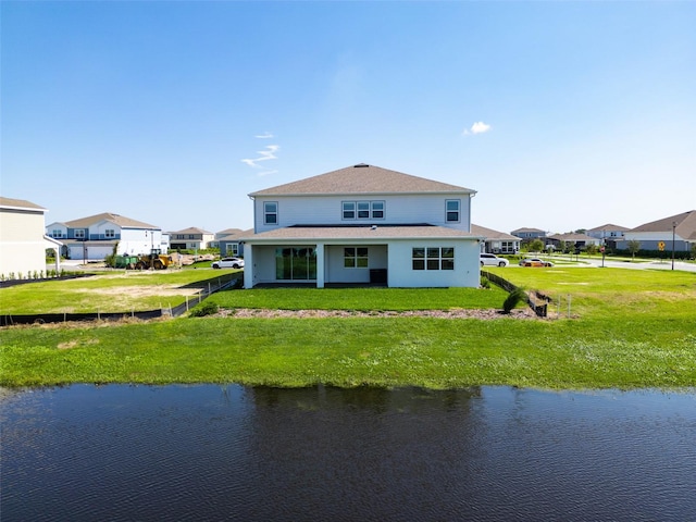 back of property featuring a water view and a yard