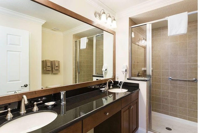 bathroom featuring a shower with door, vanity, and crown molding