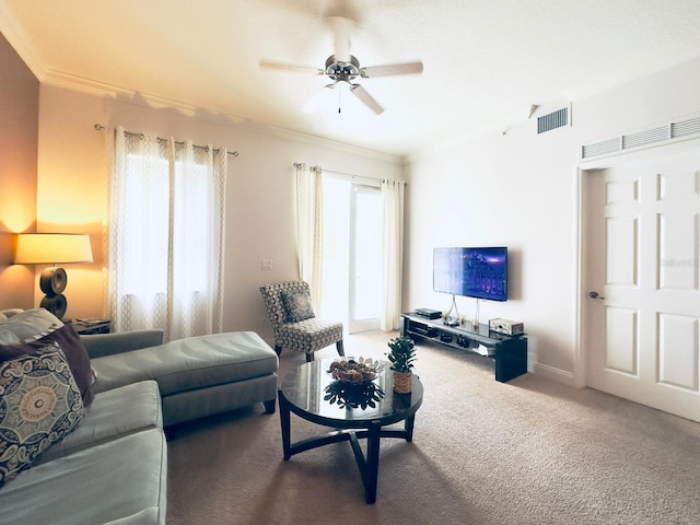 carpeted living room with ceiling fan and ornamental molding