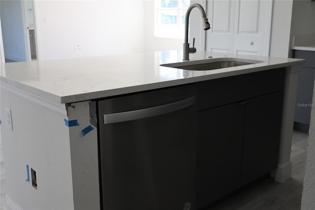 kitchen with stainless steel dishwasher, sink, and an island with sink