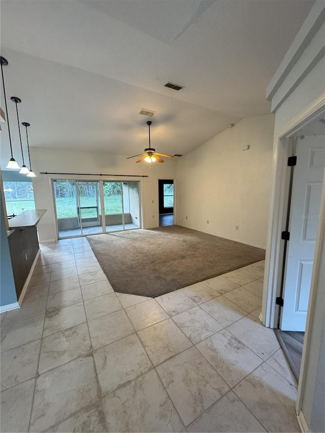 spare room with ceiling fan, vaulted ceiling, visible vents, and baseboards