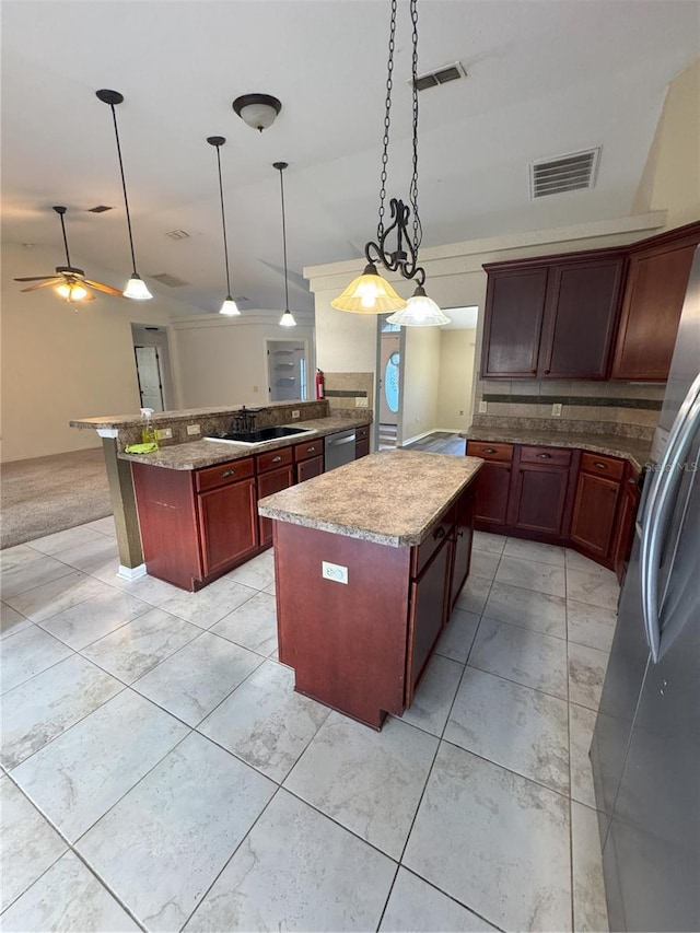 kitchen featuring a kitchen island, ceiling fan, hanging light fixtures, and stainless steel appliances