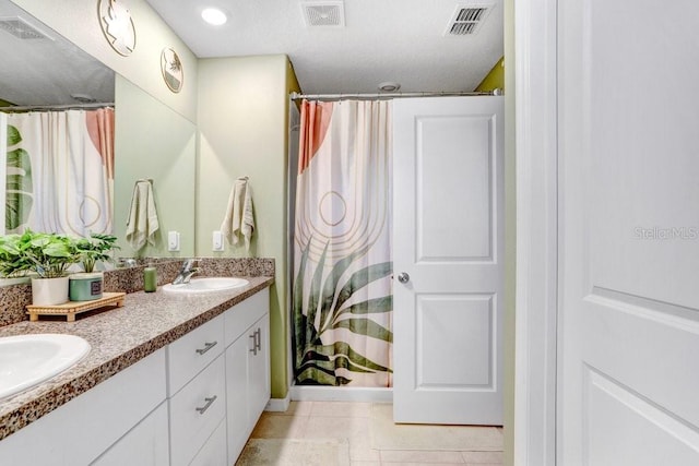 bathroom with walk in shower, tile patterned flooring, and vanity