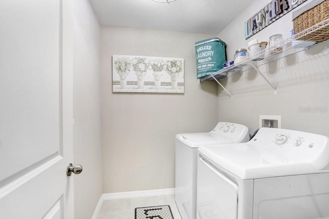 clothes washing area featuring washer and clothes dryer and tile patterned flooring