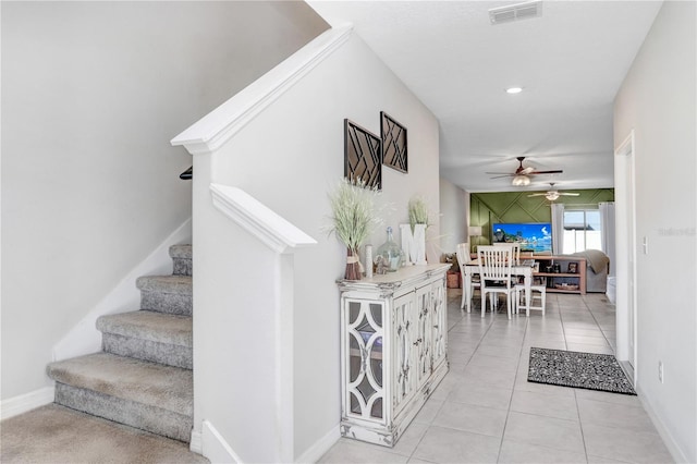 staircase featuring ceiling fan and tile patterned flooring