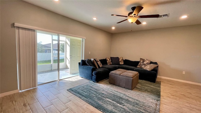 living room with ceiling fan and light hardwood / wood-style flooring