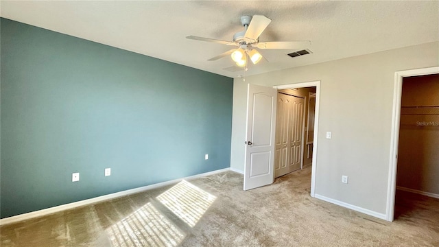 unfurnished bedroom with a closet, light carpet, and ceiling fan