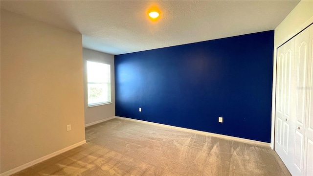 empty room with a textured ceiling and carpet flooring