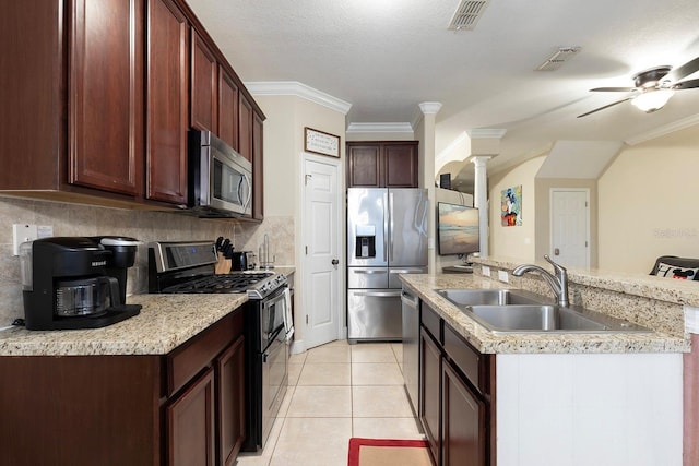 kitchen featuring stainless steel appliances, ornamental molding, decorative columns, and sink