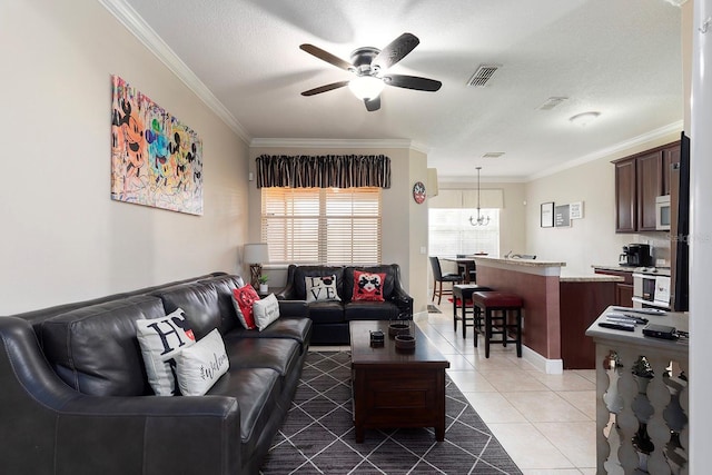 living room with ceiling fan with notable chandelier, dark tile patterned floors, ornamental molding, and a textured ceiling