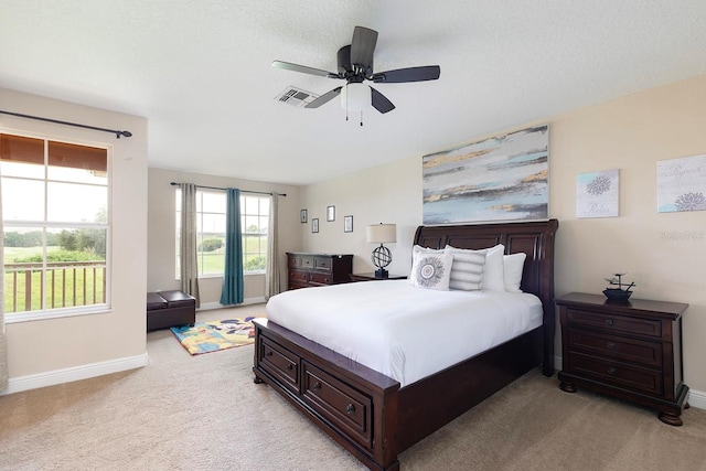 carpeted bedroom featuring ceiling fan and a textured ceiling