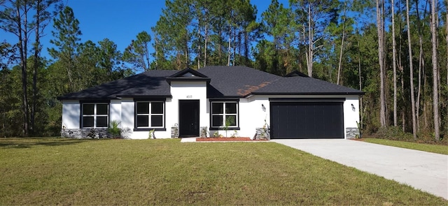 view of front of home with stucco siding, an attached garage, concrete driveway, and a front yard